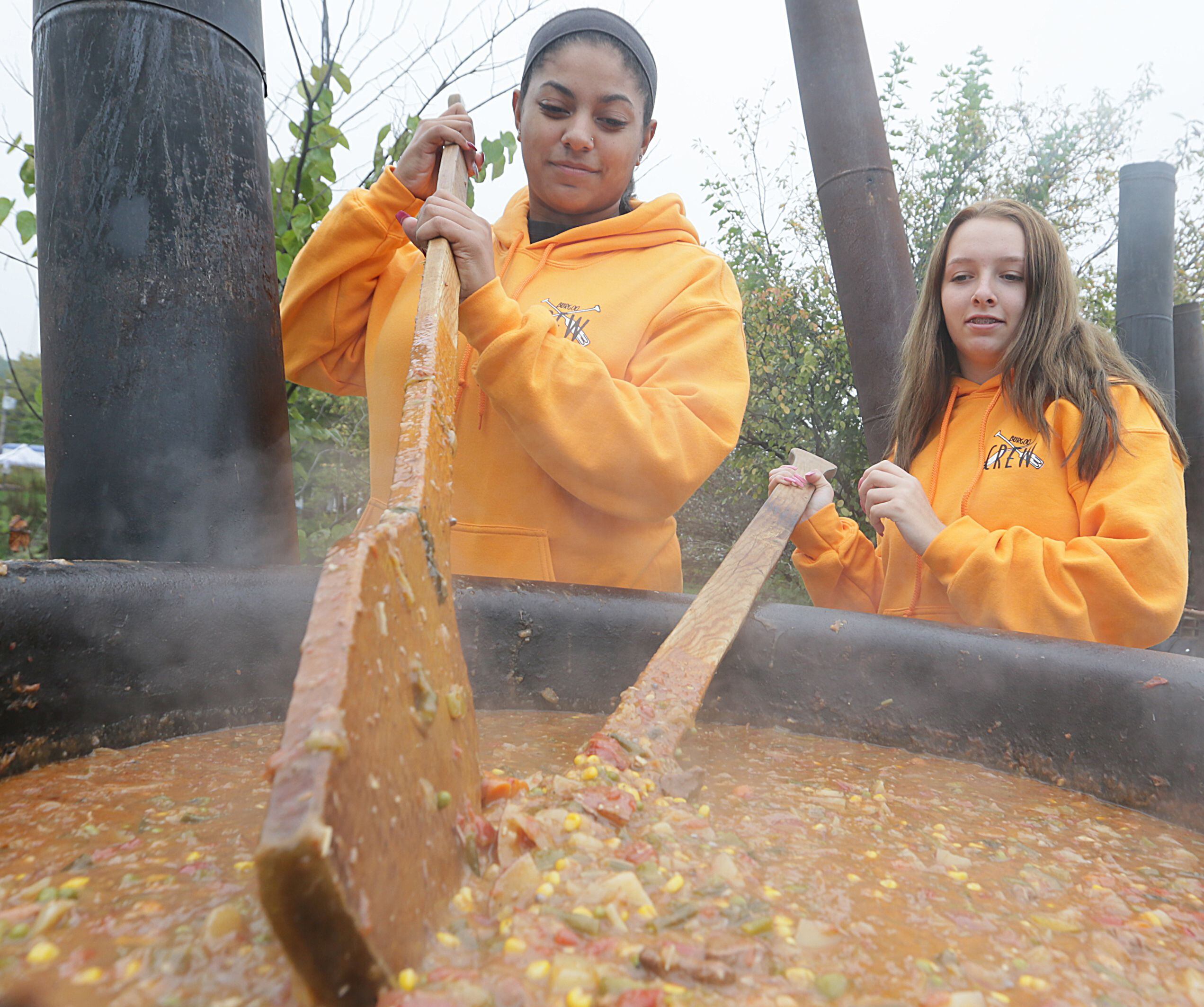 Hayley Williams, of Ottawa and Tiana Grieves, of Marseilles stir one of the six large kettles used to make the Burgoo on Oct. 13, 2019.