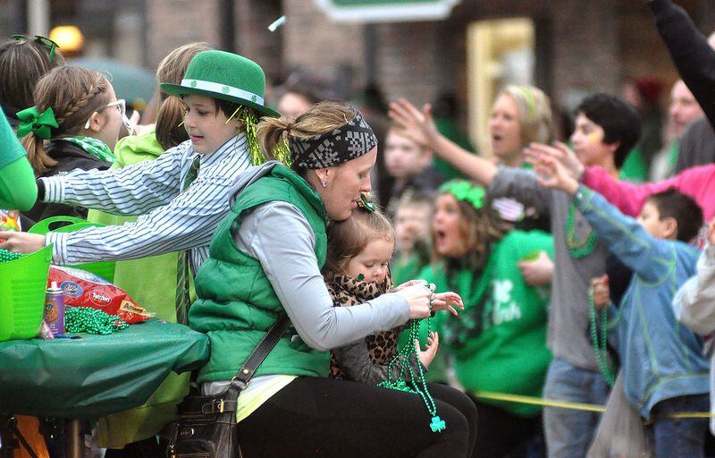 Members of the Clarks Run Antiques float throw candy and beads to the crowd Saturday during the annual St. Patrick's Day parade in downtown Utica. St. Patrick's Day is Thursday.
