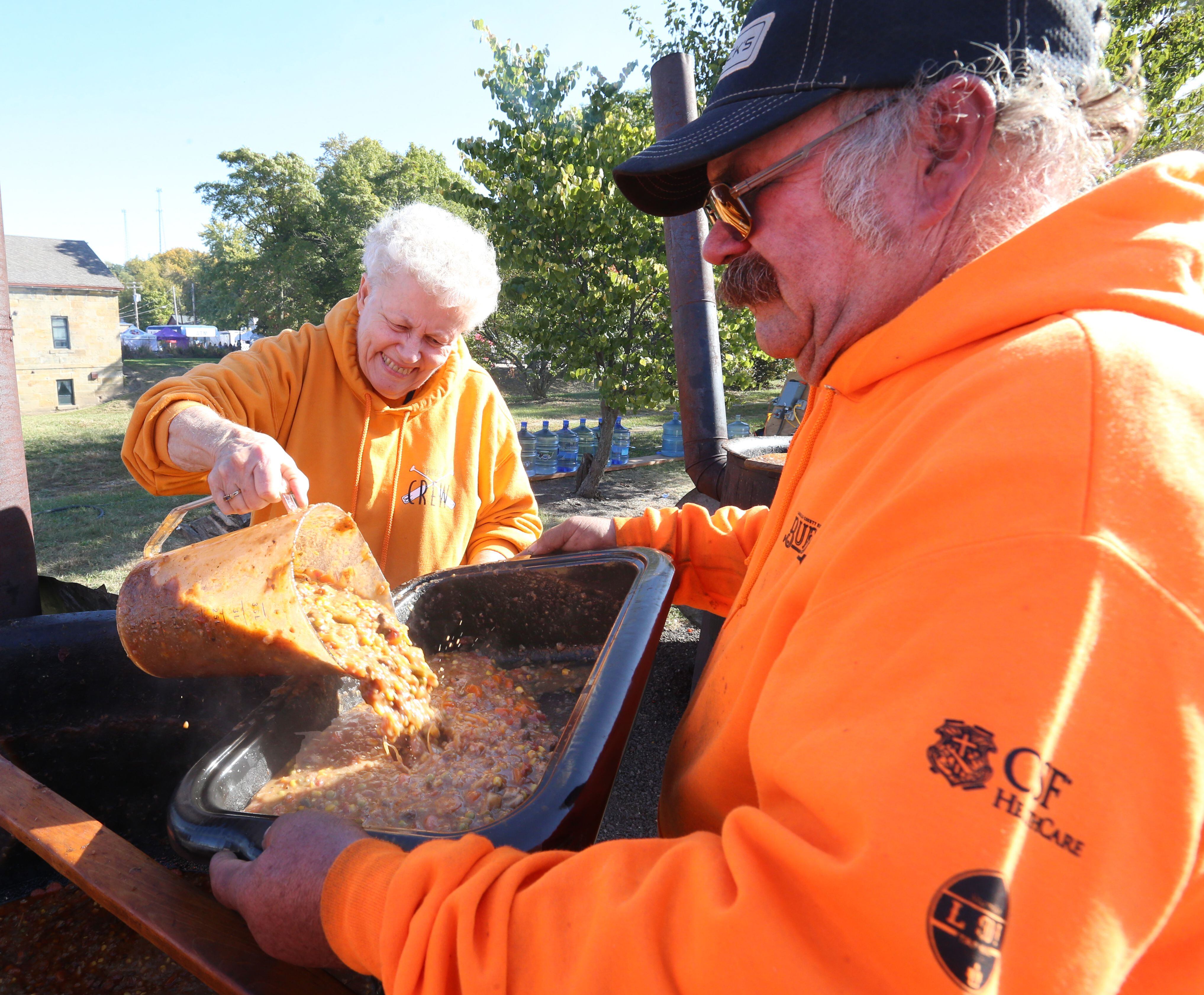 Volunteers Ruth Herbst pours a batch of Burgoo for Nathan Miller during the 52nd annual Burgoo on Sunday, Oct. 9, 2022.