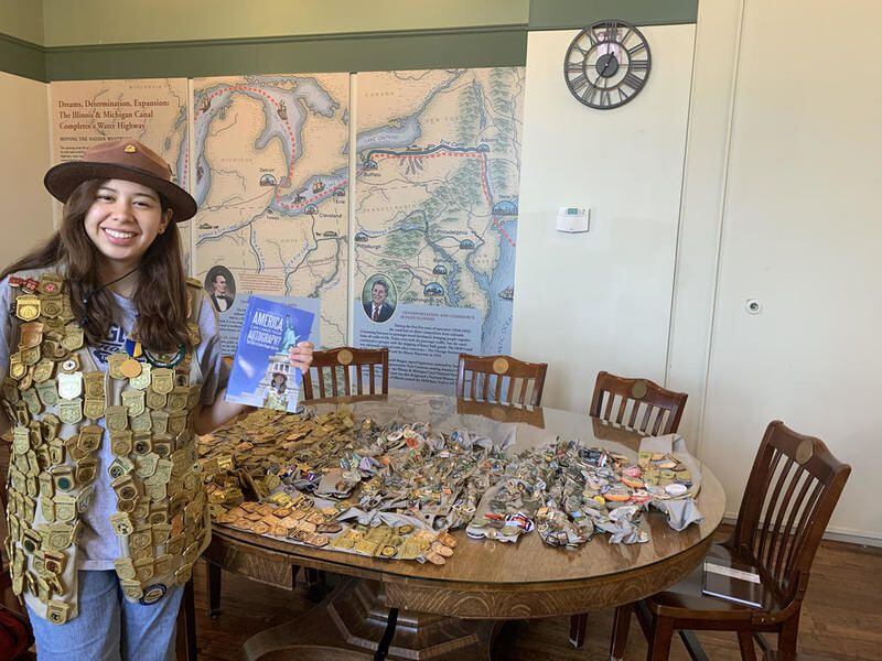 Aida Frey, 18, of Algonquin stands with the badges, pins and medals she's acquired through the National Park Service's Junior Ranger program.