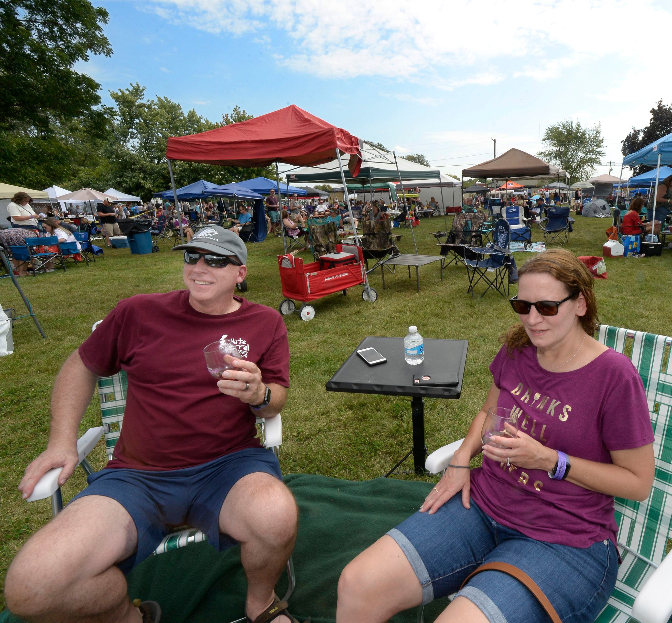 Keith and Kris Swartz, of Flanagan, along with hundreds of others, enjoy the sun and wine Saturday, Sept. 17, 2022, at Carey Memorial Park in Utica during the Vintage Wine Festival.