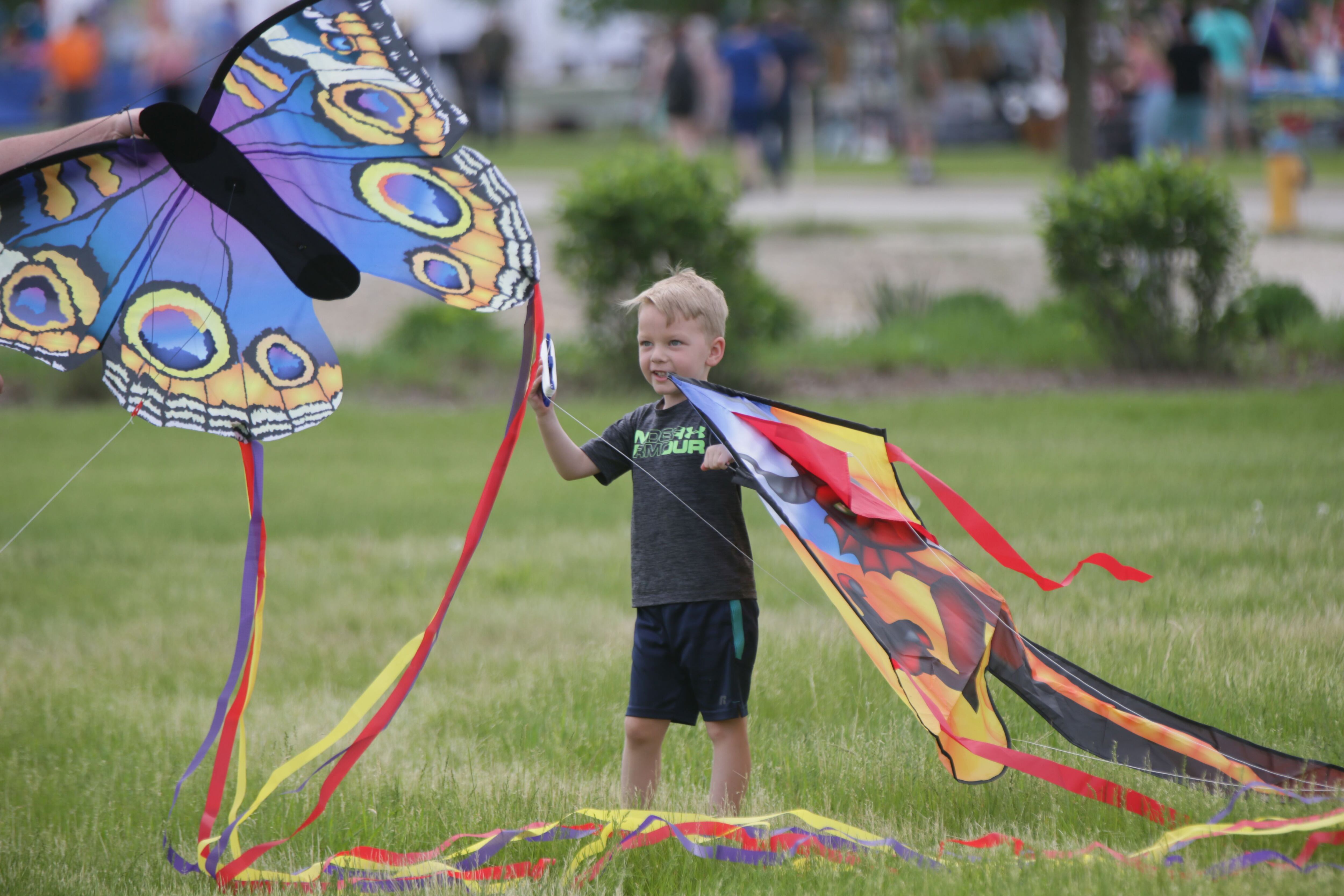 Hunter Govero of Ottawa, holds two kites as he gets ready to fly them during the 'Kites in Flight' festival on Sunday, May 15, 2022 at Heritage Harbor in Ottawa.