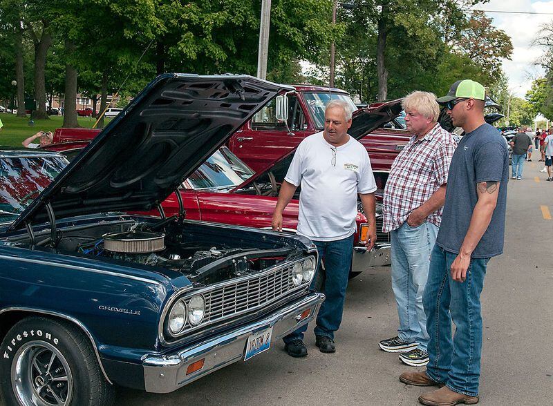 Chuck Morori, left, of Streator, talks with a couple car fans about his 1964 Chevelle SS during the Streator Dream Machines Car Club's car show. 