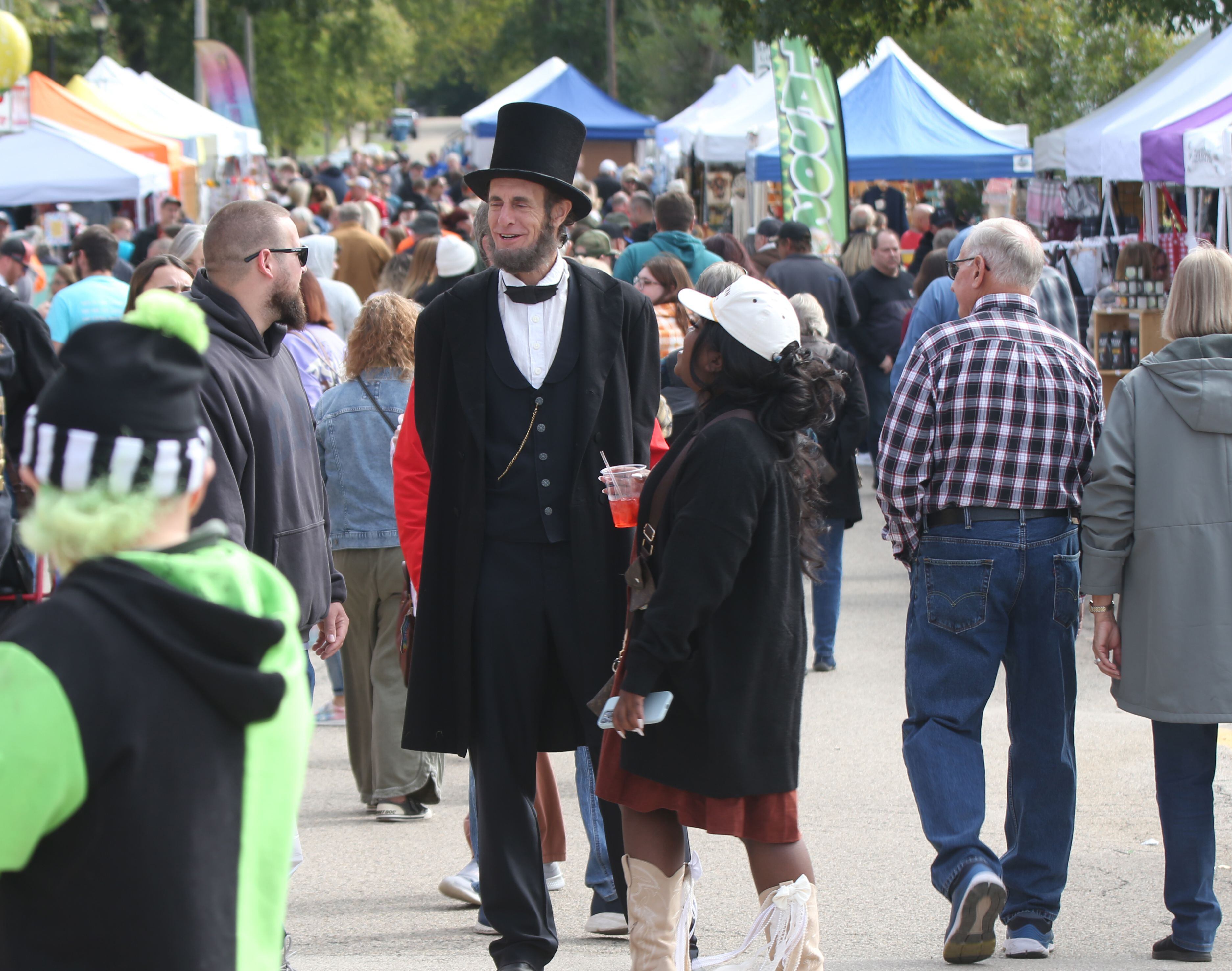 Abraham Lincoln portrayed by Kevin Wood of Adrian Mich. walks through the crowd near the corner of Mill Street and Canal Street during the 53rd annual Burgoo on Sunday, Oct. 8, 2023 downtown Utica.