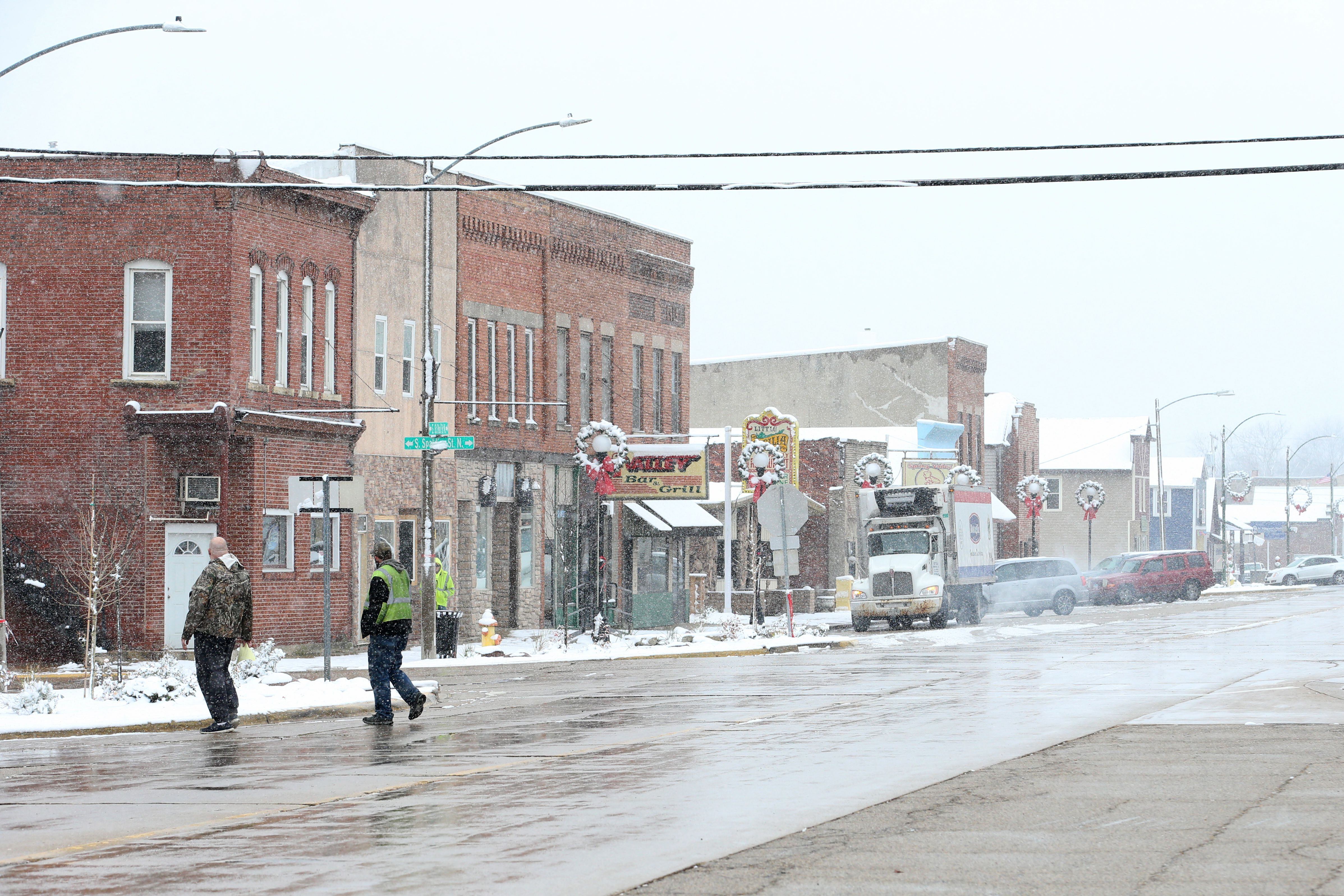 Workers walk across West St. Paul Street on Tuesday, Nov. 15, 2022 in Spring Valley.