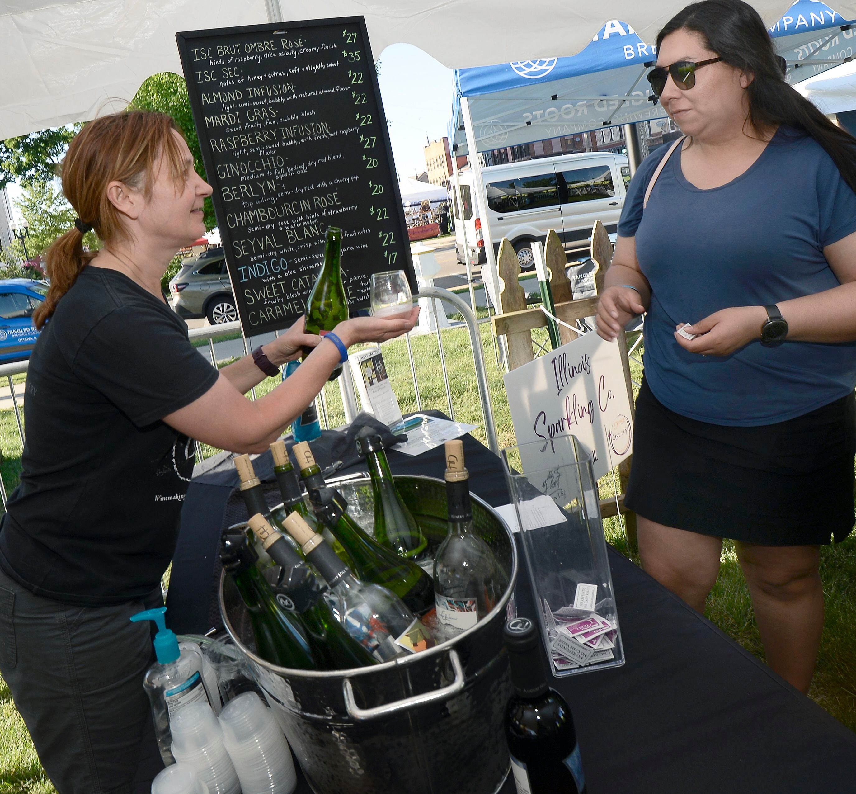 Laurie Smudzinski of August Hill Winery pours a sample of wine for a customer Friday, June 3, 2022, at Wine Fest in Ottawa. The festival runs through Sunday.