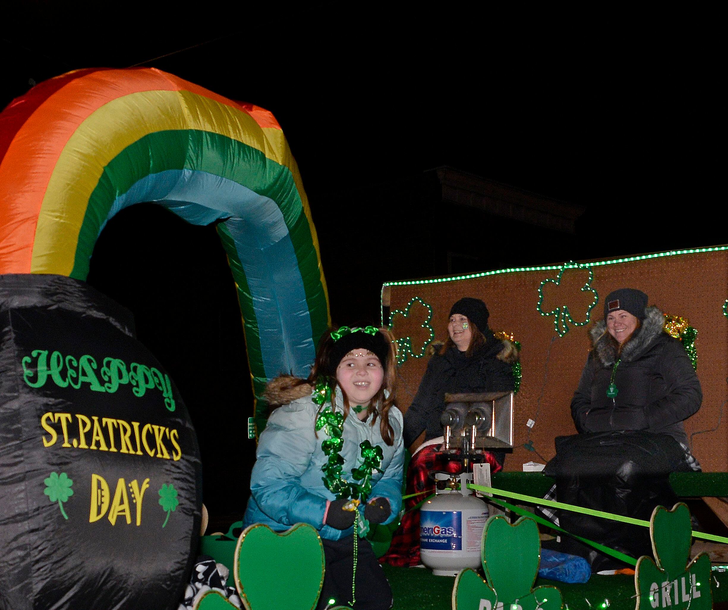 Those riding on the Ziggy’s float work to stay warm during the lighted St Patrick’s Day Parade Saturday, March 12, 2022, in Marseilles.