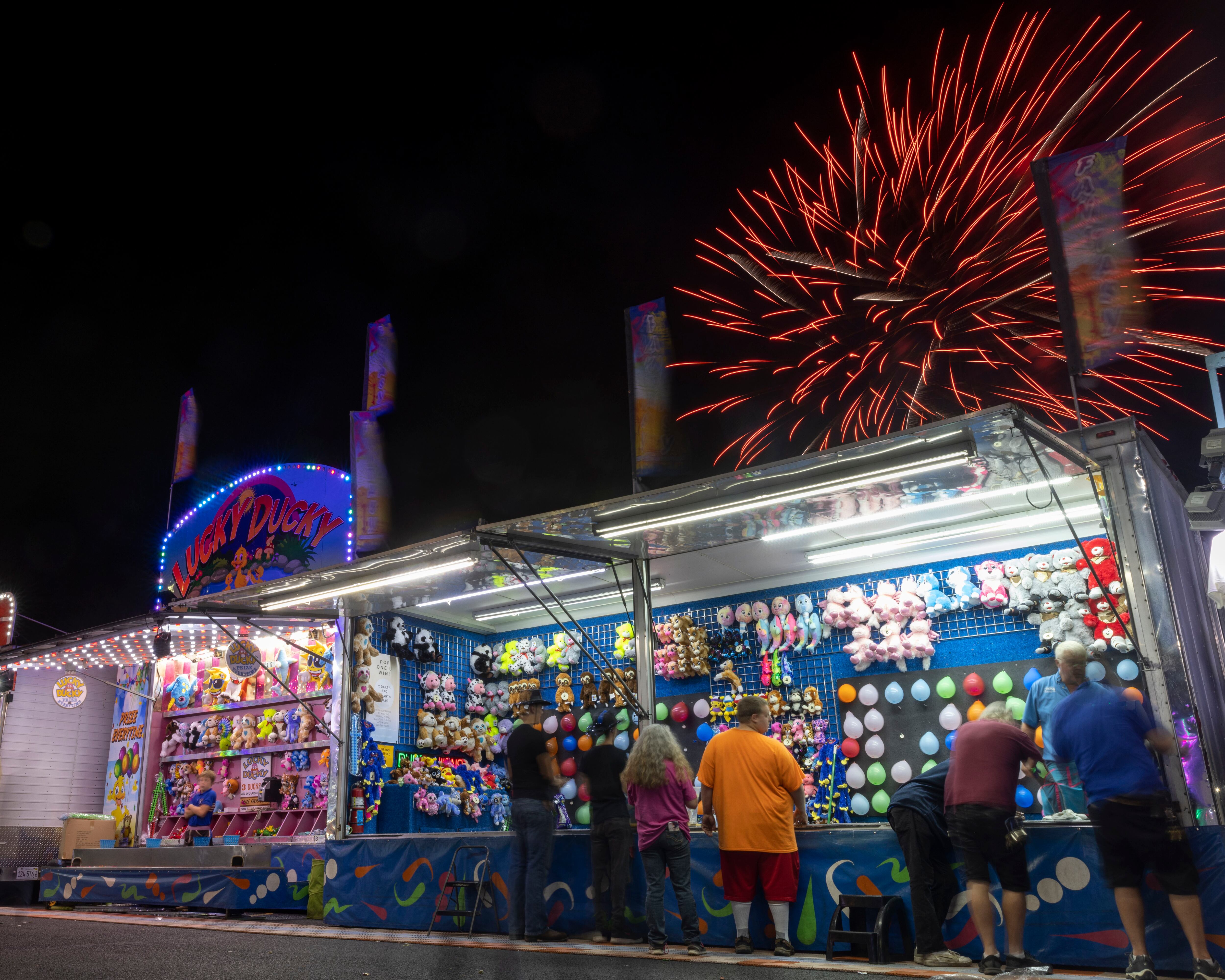 Fireworks burst over a row of carnival games Saturday, Aug. 4, 2023, during Streator Fest at Northpoint Plaza.