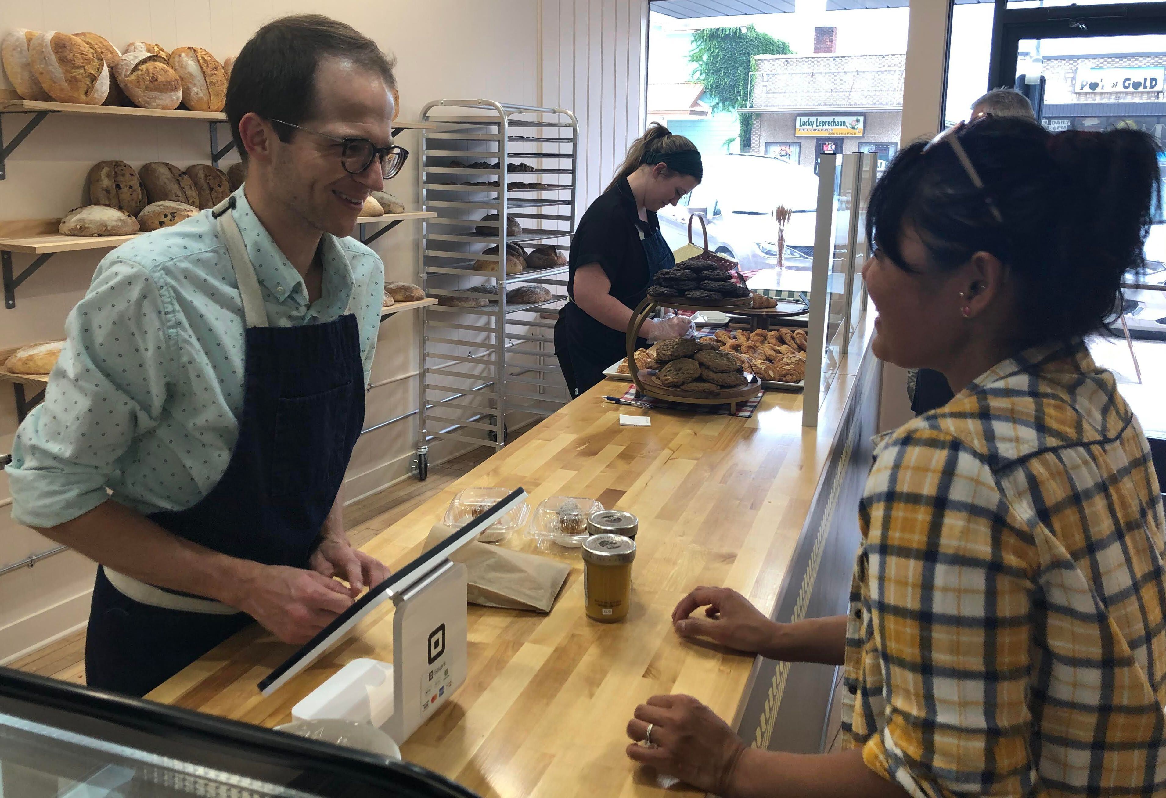 Co-owner Kent Maze helps a customer check out at Millstone Bakery in downtown La Salle.